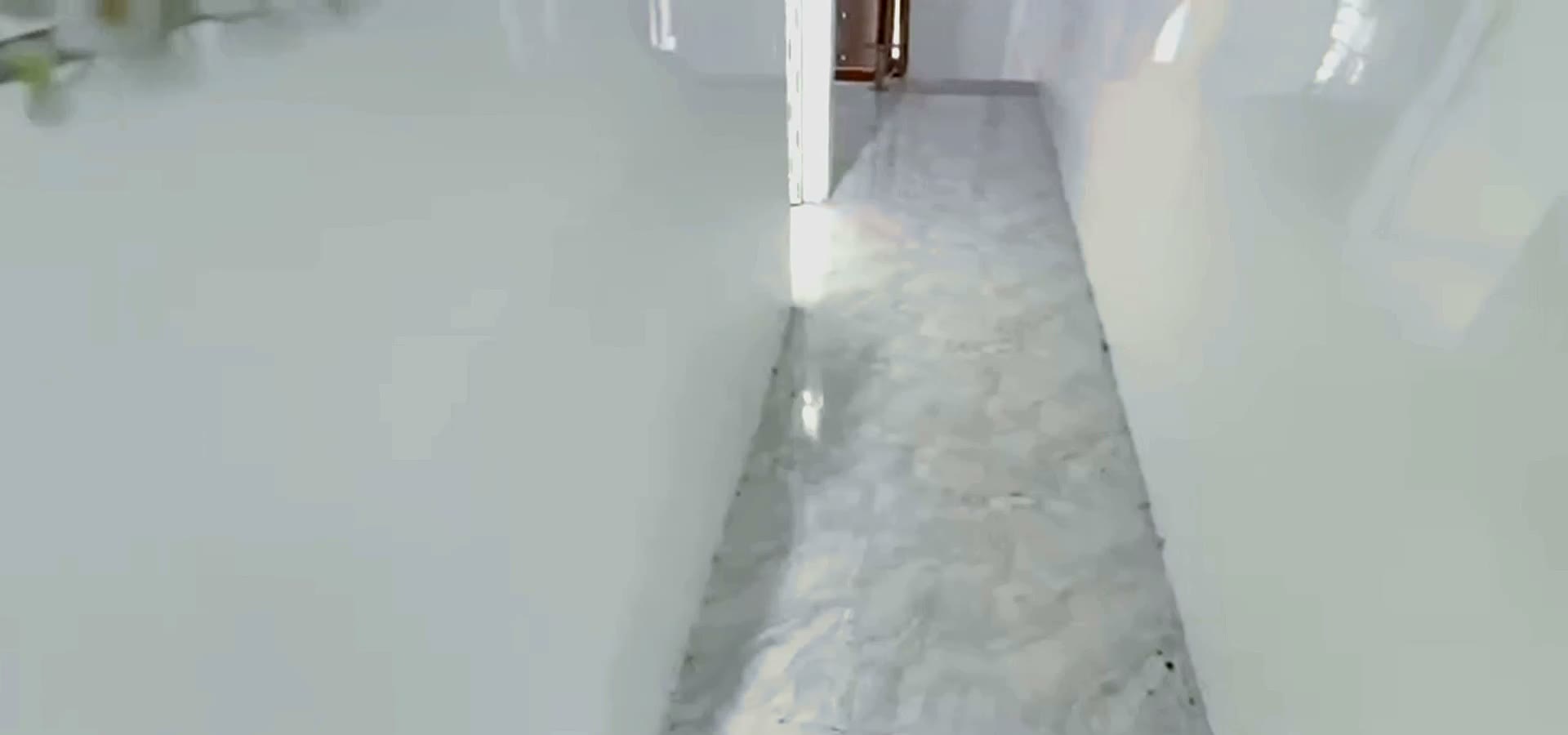 Toilet lát gạch trắng có bồn cầu và vòi sen trong nhà gác lửng