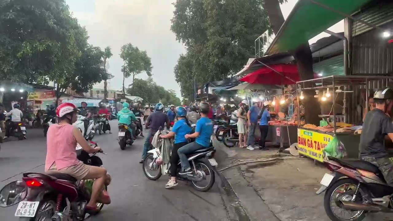 Khu chợ đông người gần dãy trọ Mỹ Phước 3, xe máy và hàng quán hai bên đường