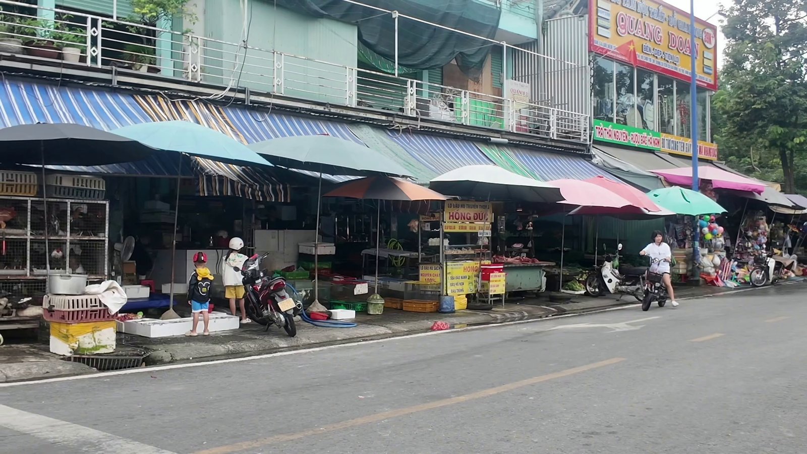 Chợ tự phát Hòa Lợi với dãy sạp hàng hai bên đường, gần căn nhà kinh doanh có dãy trọ