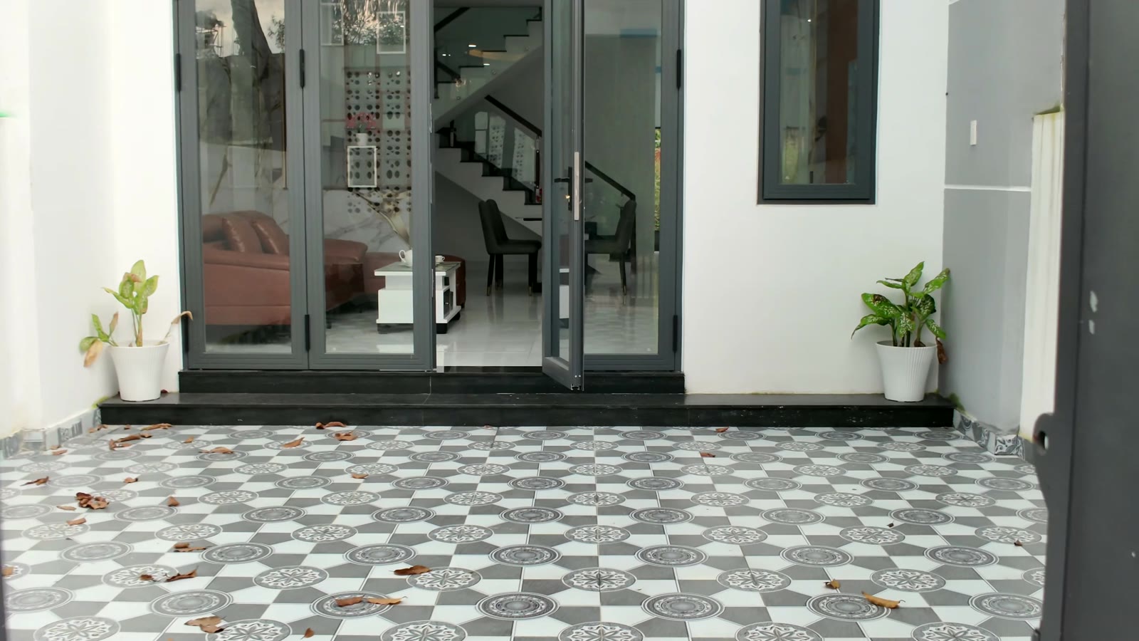 Sân trước và cửa kính căn nhà 1 trệt 1 lầu trong tái định cư khu công nghiệp Mỹ Phước 3