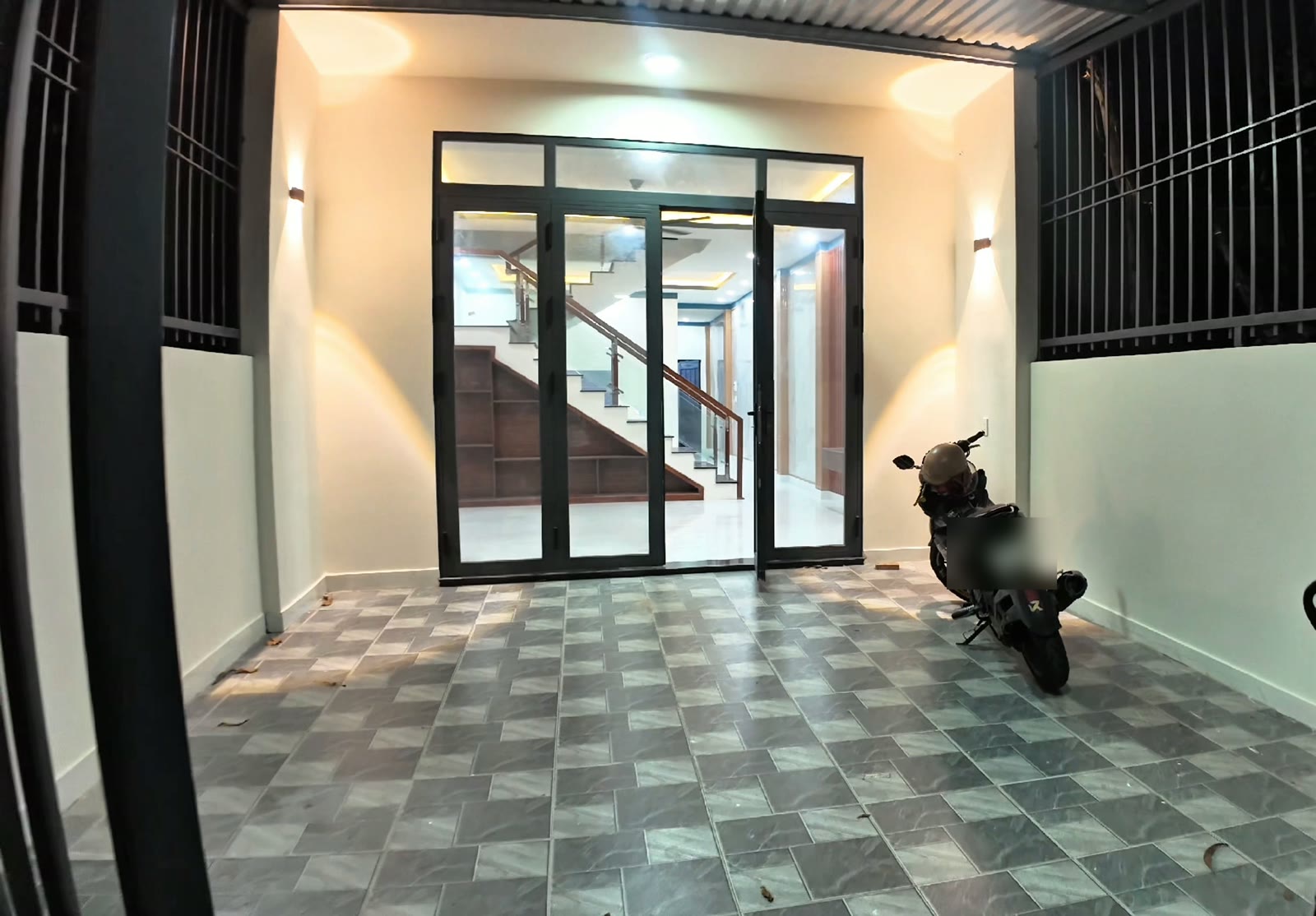 Sân trước nhà lầu trệt 5x20 Mỹ Phước có mái che, bờ rào sắt, đủ chỗ đậu xe hơi 7 chỗ